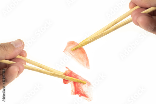 eating pickled ginger with chopsticks isolated on a white background