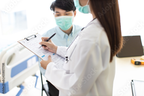 Medicine and health care concept. Asian woman doctor is taking care patient in hospital.doctor or nurse wear protection mask checking and takecare infection people from covid-19 .