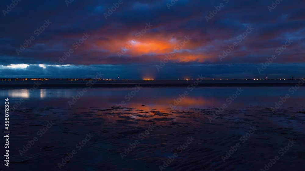 Lockdown time lapse shot of reflection on shore at beach against cloudy sky during sunset - Crescent Beach, Canada Lockdown time lapse shot of reflection on shore at beach against cloudy sky during sunset - Crescent Beach, Canada