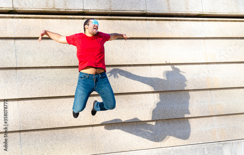 young boy of generation Y in flight during a jump, creative and inappropriate use of protective masks, a symbol of optimism and positivity for the future by the younger generations