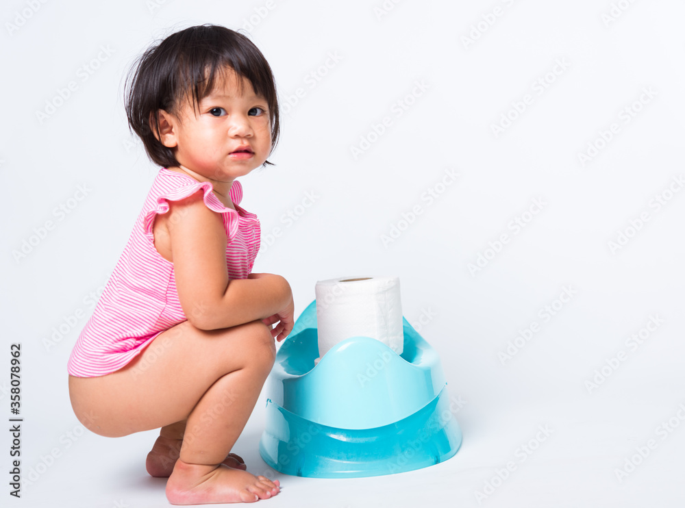 Asian little cute baby child girl education training to sitting on blue chamber pot or potty with toilet paper rolls, studio shot isolated on white background, wc toilet concept Asian little cute baby child girl education training to sitting on blue chamber pot or potty with toilet paper rolls, studio shot isolated on white background, wc toilet concept