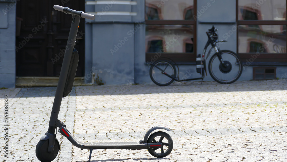 Electric scooter parked on cobblestones in the city center.