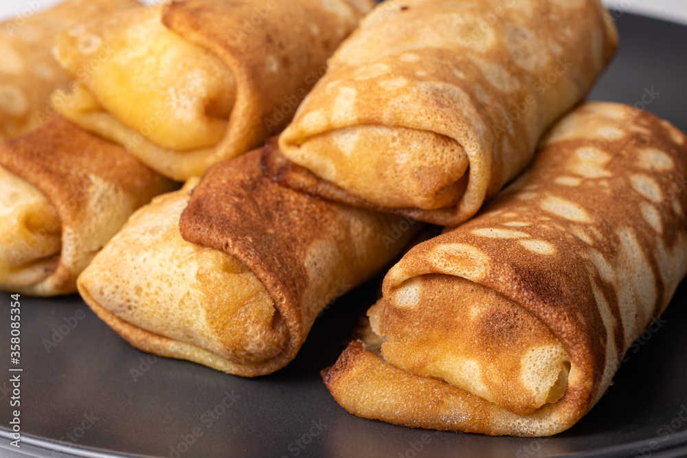 Pancakes stuffed on a black background. Homemade pastries, gluten-free and wheat flour.