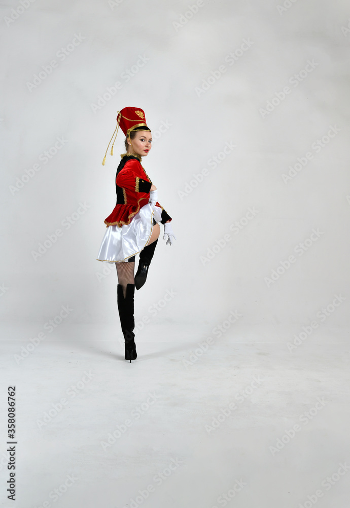 Obraz premium beautiful girl in red hussar uniform marching with a sword