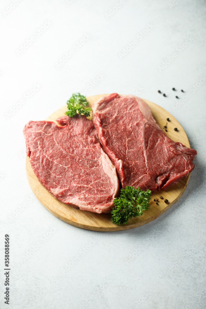 Raw beef steak on a wooden desk