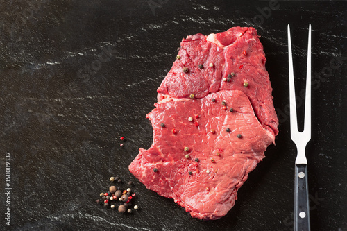 Steak raw. Barbecue Rib Eye Steak or rump steak on black stone