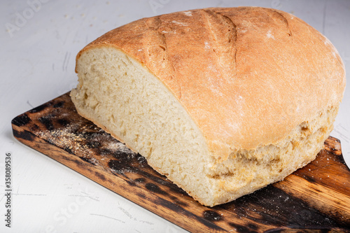 Chleb własnej roboty. Domowe wypieki. Wyrob z maki pszennej. Smacznie i zdrowo. Swieze pieczywo na stole w kuchni. Dla wegetarian.