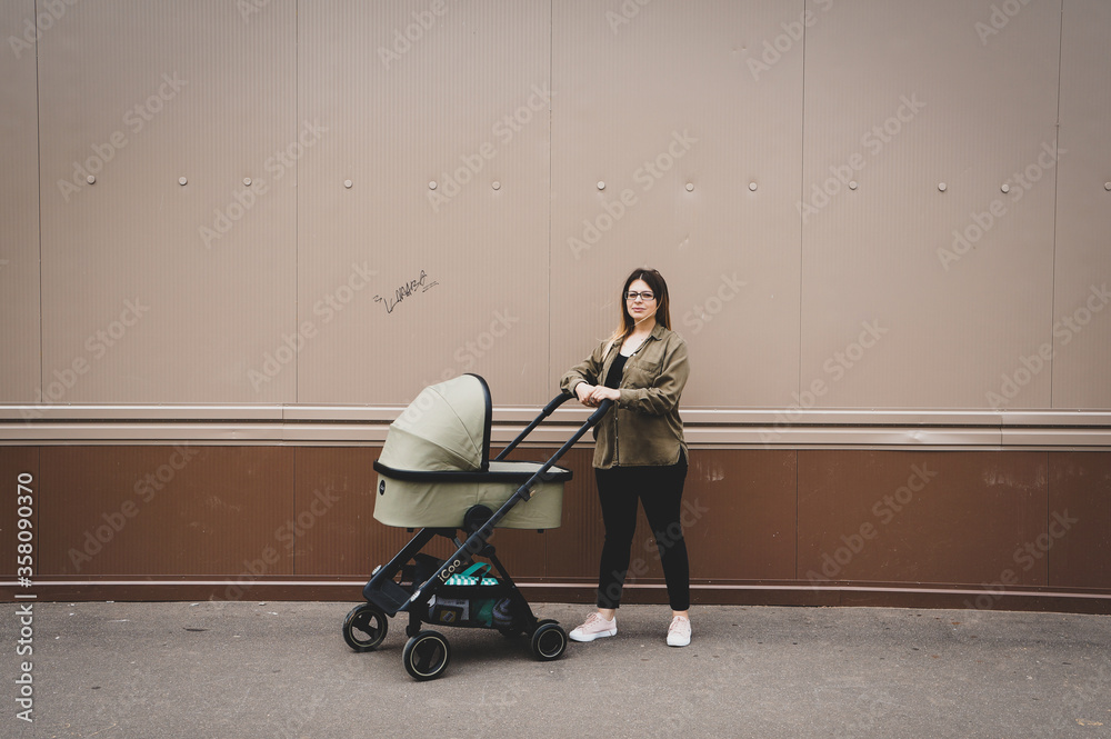 beautiful young mother walks with a stroller beautiful young mother walks with a stroller