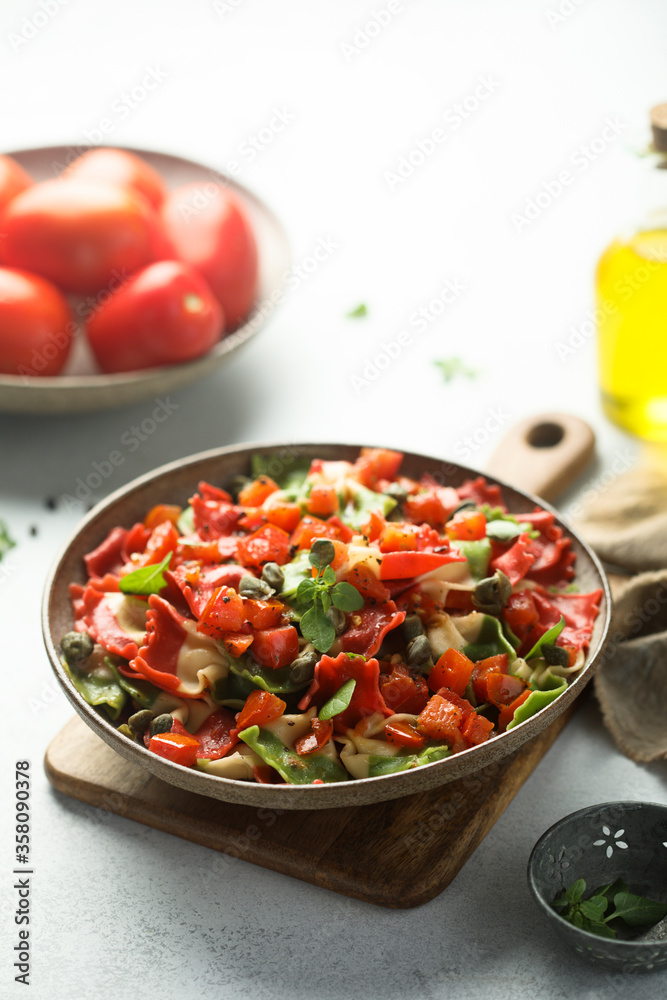 Multi-colored Italian pasta with capers and tomatoes