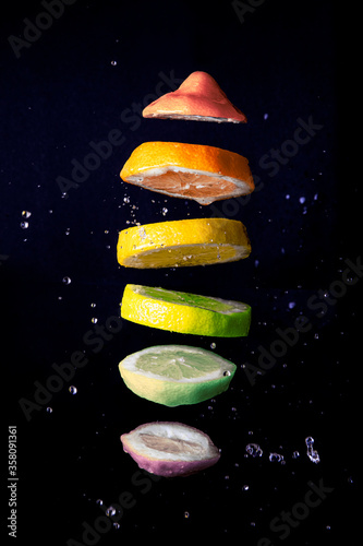 Limón con colores de la bandera gay cortado en rodajas y gotas de agua	 photo