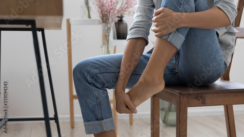 Fotografie Close up of exhausted businesswoman touch massage foot suffer from uncomfortable