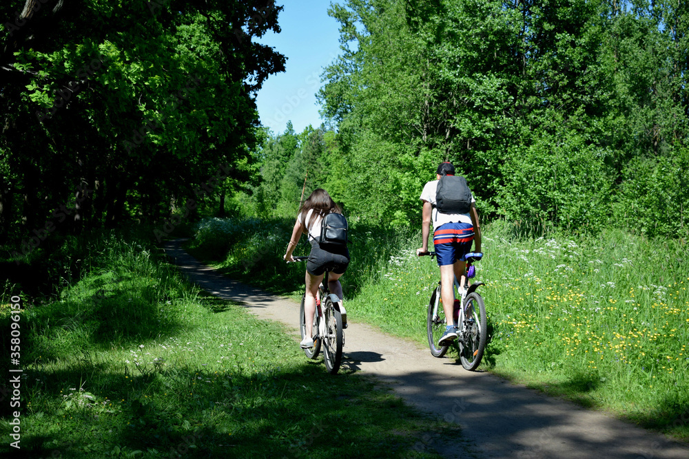 Fototapeta premium young couple riding bikes in park