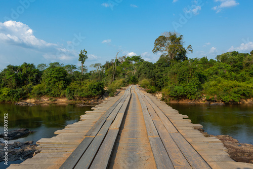 Wooden rustic bridge over river in dangerous dirt road in the amazon rainforest, Brazil. Driver POV. Concept of transport, logistics, travel, ecology, danger, off road and co2.