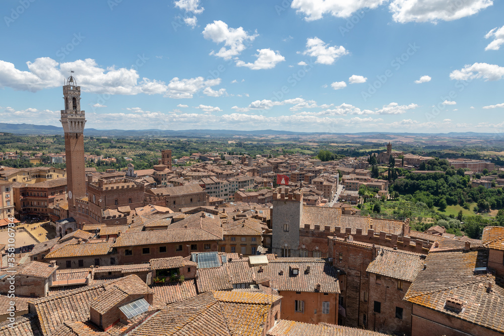Panoramic view of Siena city with historic buildings and far green fields
