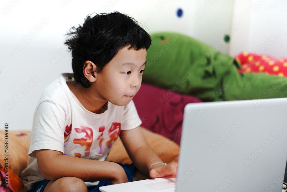 Asian boy learning from home by notebook broadcasting technology Asian boy learning from home by notebook broadcasting technology