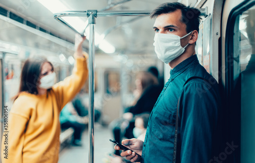 young man in a protective mask looking at the screen of his smartphone © yurolaitsalbert