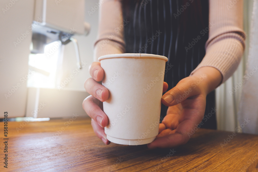 Close up image of a barista serve take away coffee in a coffee shop. Close up image of a barista serve take away coffee in a coffee shop.