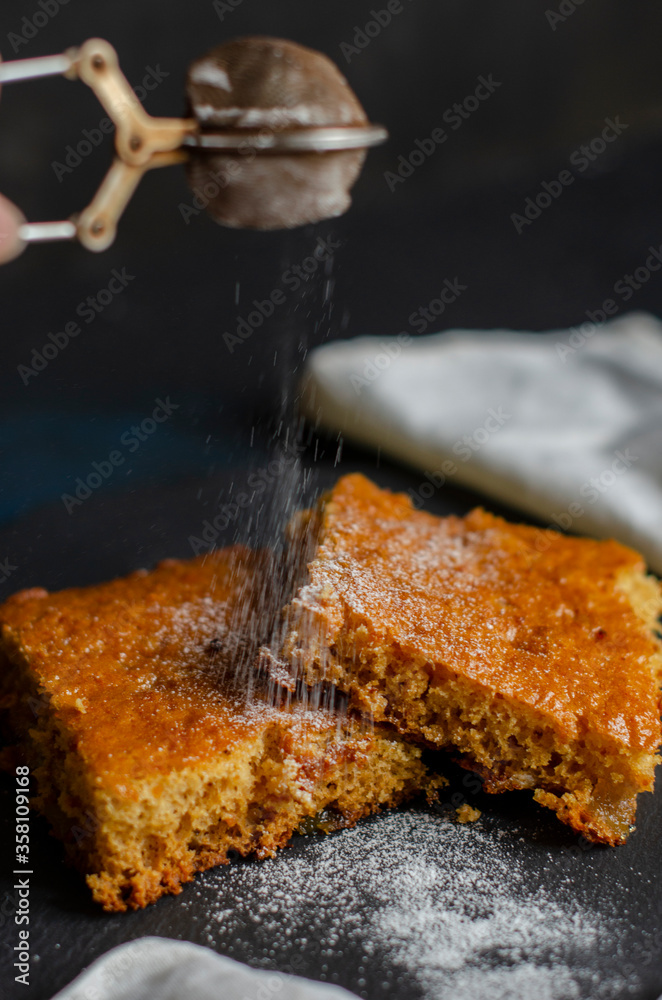 Fototapeta premium cake on the table sprinkled with powdered sugar