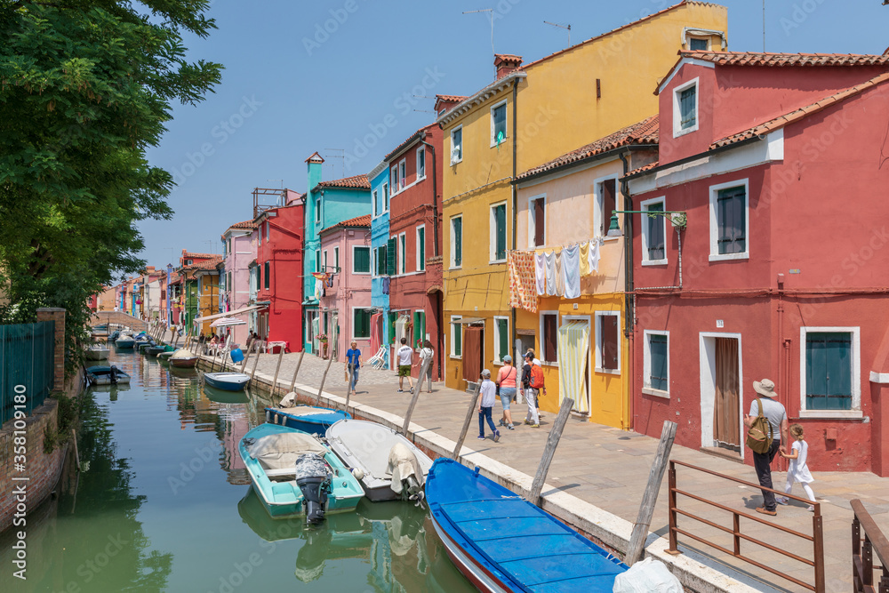 Fototapeta premium Panoramic view of coloured homes and water canal with boats in Burano