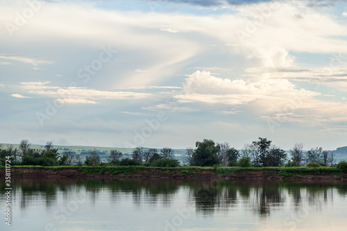 The sky and the forest are reflected in the river.
