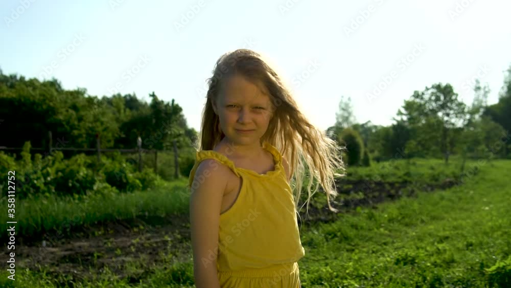 Joyful young girl with beautiful eyes looks at the camera, look serious and in love, even joyful to enjoy the concept against the background of blue sky and green grass on vacation. Green grass Joyful young girl with beautiful eyes looks at the camera, look serious and in love, even joyful to enjoy the concept against the background of blue sky and green grass on vacation. Green grass