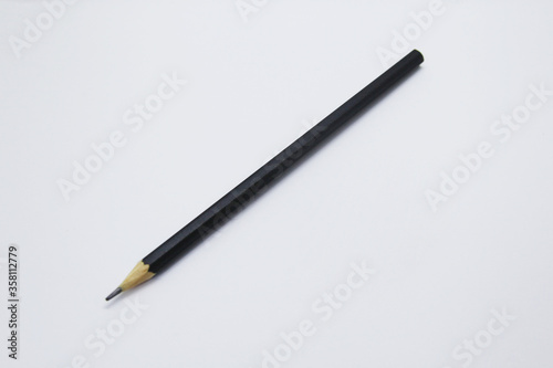 Black pencil, an instrument used to write, draw or doodle is cylindrical and wooden in shape with a graphite on the inside