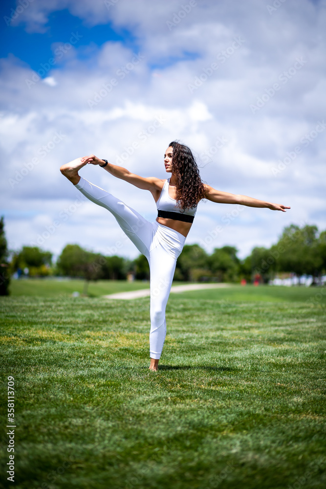 Young pretty fitness woman doing yoga postures in a park on the grass with white clothes Young pretty fitness woman doing yoga postures in a park on the grass with white clothes