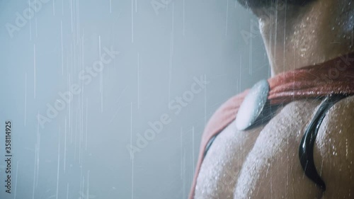 Spartan holding helmet under rain.