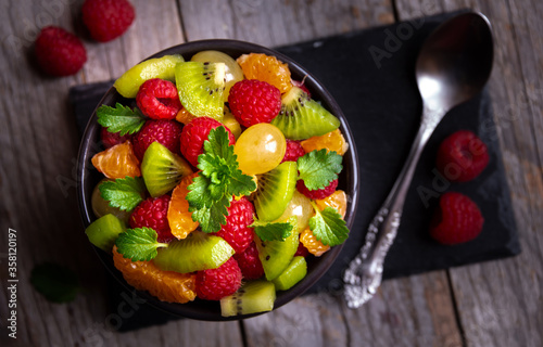 Fresh fruit salad with with raspberry, mandarin and other fruit