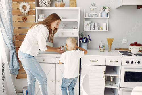 Cute little son with mother. Family at home in a kitchen. © hetmanstock2