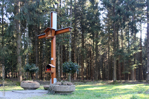 Kreuz, Gedenkstätte in einem dicht bewaldeten Tannenwald.