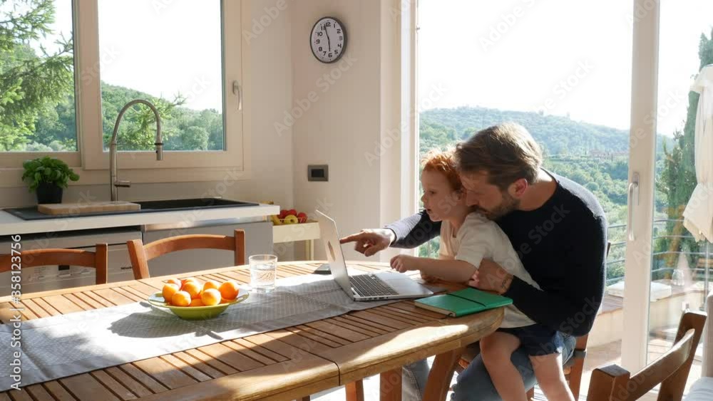 Father and son using laptop at home