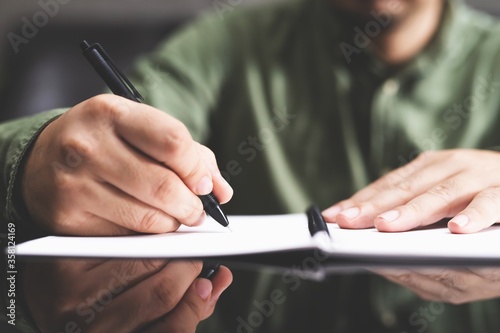 image of  businessman writing  on notepad. photo