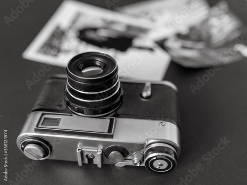 vintage film camera with black and white pictures laying on the table. Vintage, film, old technology concept