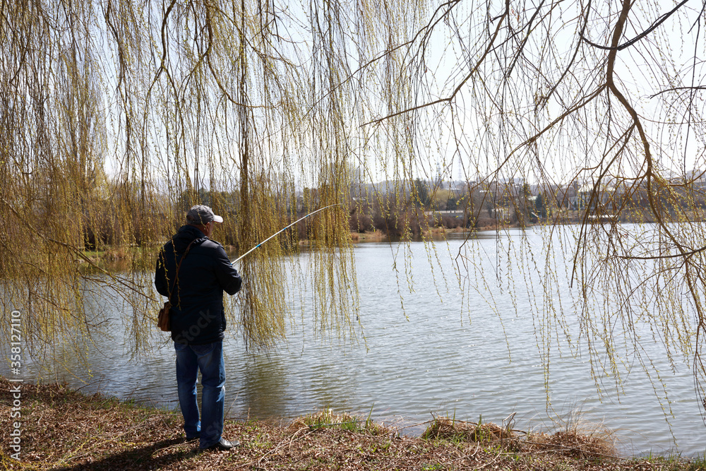 Man fishing on lake in spring Man fishing on lake in spring