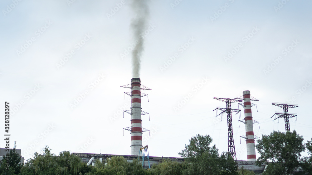 Obraz premium Pipe of the plant with which there is smoke against the sky. Factory and environmental topics of environmental pollution. Stock background for design.