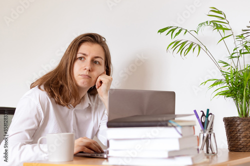 Work from home. Woman drinking coffee and using digital tablet in the morning. Hands on laptop