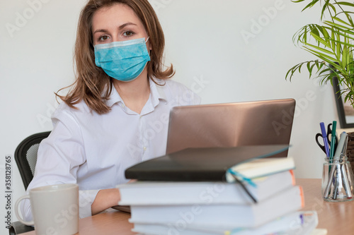 Woman in quarantine for Coronavirus wearing protective mask and smart working
