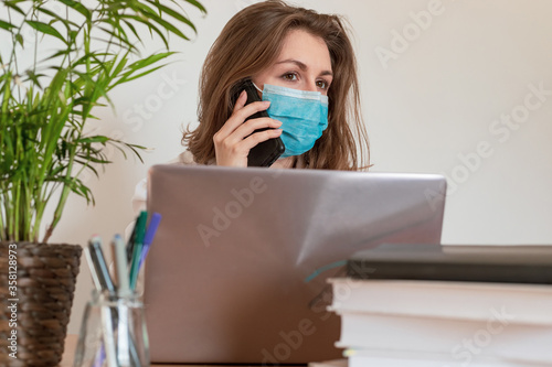 Woman in quarantine for Coronavirus wearing protective mask and smart working