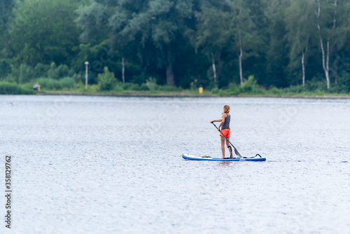 girl on a paddleboard out on the water lake, young, lifestyle, copyspace