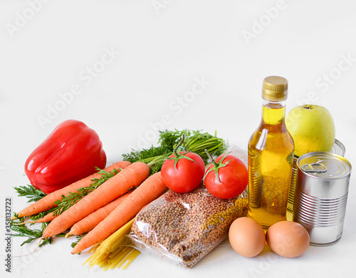 Food set: buckwheat, pasta, vegetables, canned food, eggs, vegetable oil on a white background. Food delivery, Donation. food supplies stock on white background. Top view,Copy space