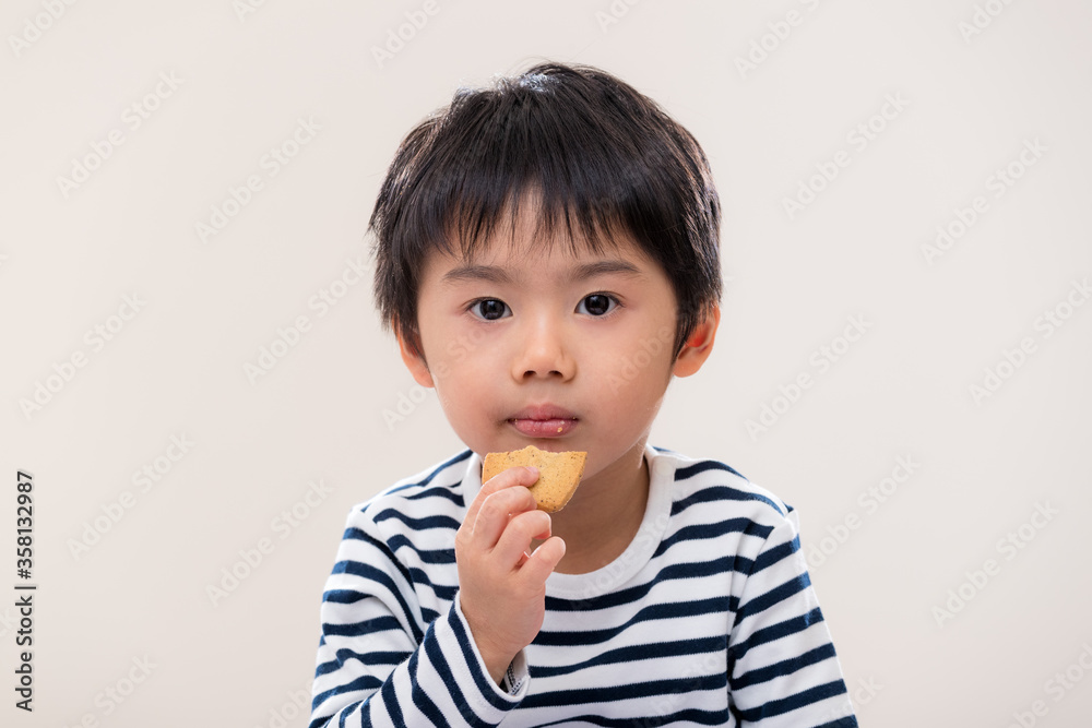 Kid boy eat cookie on white background Kid boy eat cookie on white background