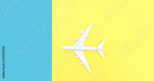 toy airplane on a double yellow-blue background. Summer vacation concept, travel.