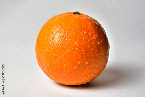 One orange with water droplets