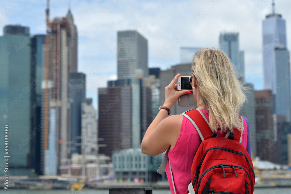 Woman taking picture New York city skyline