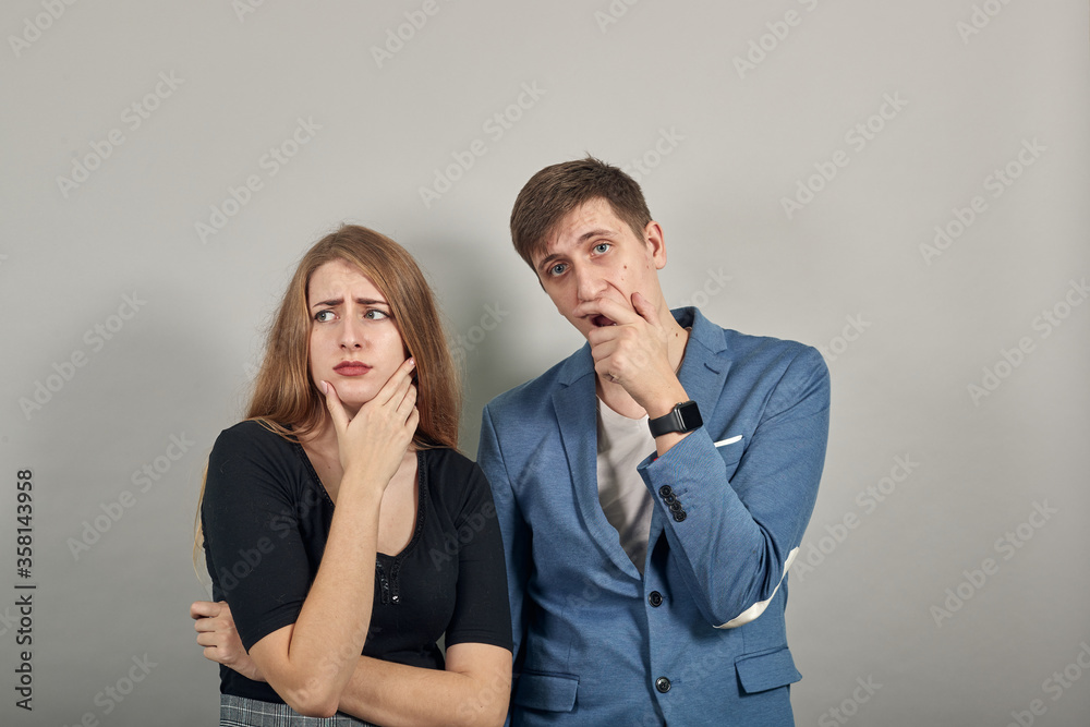 Hand on chin thinking about question, pensive expression. Doubt. Thoughtful face. Using that incredibly sharp business mind. Young attractive couple boyfriend girlfriend two people, dressed t-shirt Hand on chin thinking about question, pensive expression. Doubt. Thoughtful face. Using that incredibly sharp business mind. Young attractive couple boyfriend girlfriend two people, dressed t-shirt