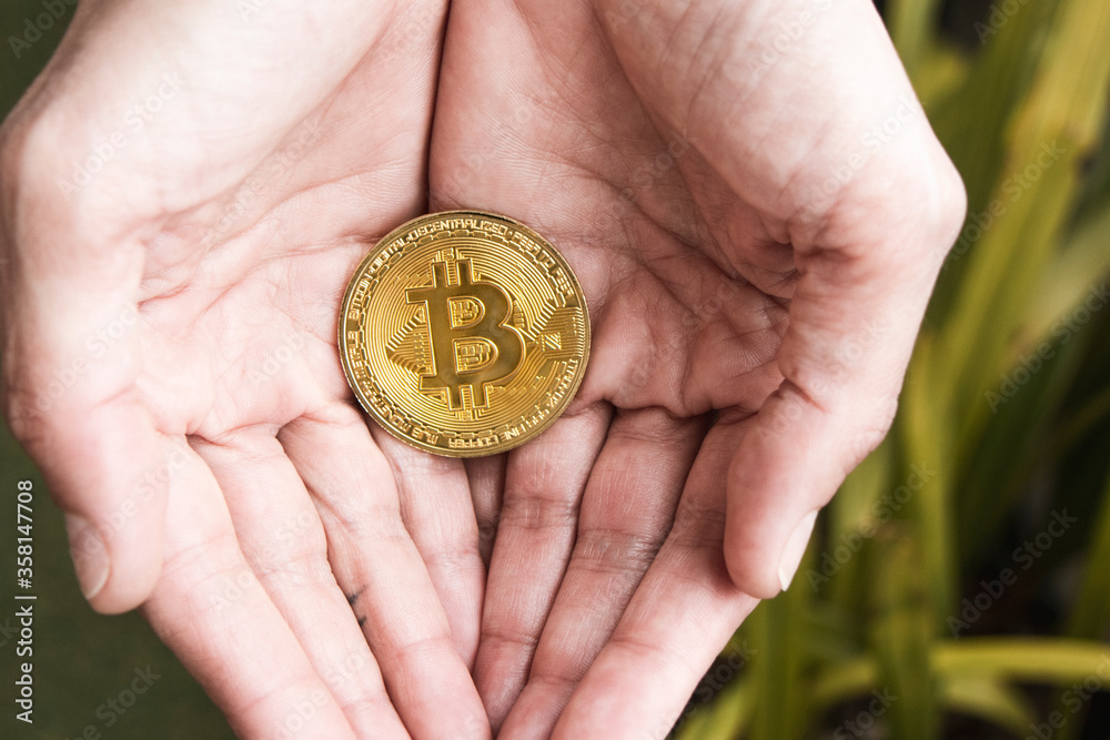 Bitcoin coin in a woman's hands Bitcoin coin in a woman's hands