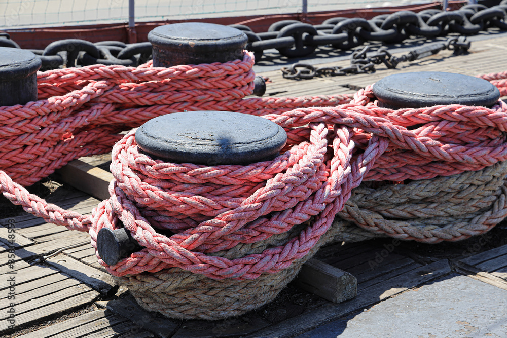 The mooring rope is fixed on the bollard on the deck of the old ship