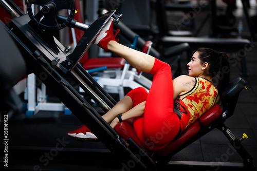 Girl in the gym. Goes in for sports, on exercise machines