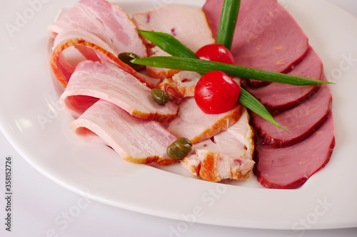 Meat platter. Cold cuts. Ham, bacon, chicken fillet. White background